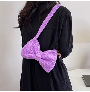 Détail du sac à bandoulière en tricot violet avec nœud fait main sur le dos du modèle