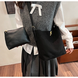 Vue détaillée du sac seau noir en daim avec boucles dorées et une bandoulière réglable
