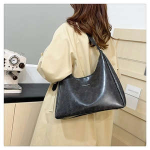 Fashionable black PU leather hobo bag with large capacity shown on model in beige trench coat