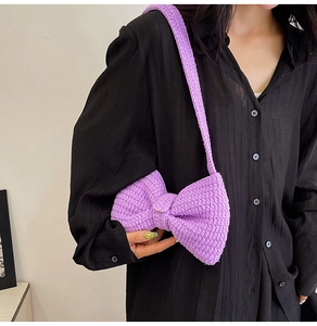 Détail d'un sac à bandoulière en maille violet clair avec grand nœud porté par un mannequin