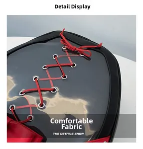 Detail view of gothic style black backpack featuring red cross-lacing and clear PVC panel