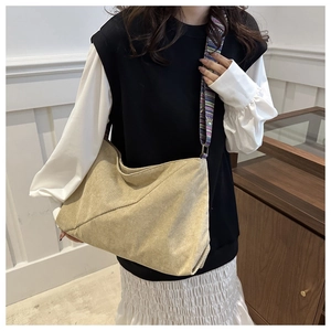 Gros plan du sac cabas beige en velours côtelé avec une bandoulière tissée ethnique