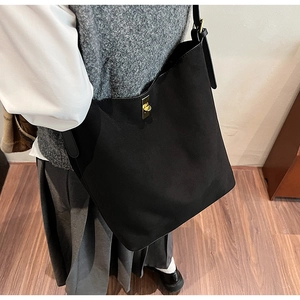 Détail du sac fourre-tout noir avec texture mate raffinée et boucle en métal doré chic