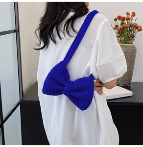 Détail de la texture en maille du sac à bandoulière bleu vif avec nœud sur mannequin