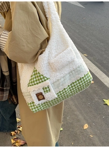 Détail du sac en peluche montrant la bordure en dentelle et la poche maison à bouton