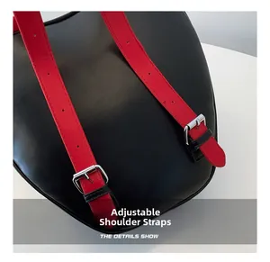 Detail view of adjustable red shoulder straps on a black leather commuter backpack