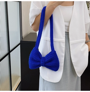 Détail du sac à bandoulière en tricot bleu montrant le savoir-faire artisanal du crochet