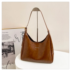 Retro caramel PU leather hobo shoulder bag with Fashion & Bags logo on a display stand