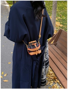 Détail du mini sac seau à cordon avec garniture en cuir beige et crochets dorés