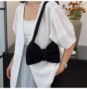 Gros plan sur le sac à bandoulière noir en grosse maille avec détail de nœud tissé