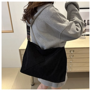Détail d'un sac cabas en velours noir avec bandoulière ethnique sur un mannequin