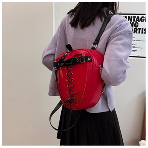 Model wearing red heart-shaped ita bag with transparent window and black lace-up details