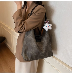 Detail of vintage grey leather tote bag with star charm and fashion logo label