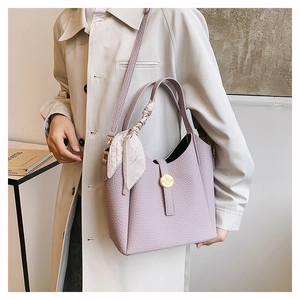 Detail view of purple bucket bag with lychee texture leather and silk scarf handle