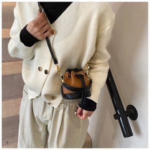 Vue détaillée du mini sac bourse bicolore marron et noir avec crochets en métal doré