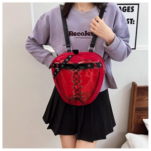 Detail shot of the red heart shaped ita bag featuring a transparent PVC window and black straps