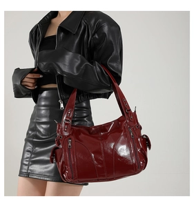 Detailed close-up of wine red PU leather tote bag with functional zipper pockets
