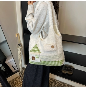 Gros plan d'un sac cabas en peluche blanche avec motif maison verte et dentelle sur mannequin
