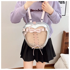 Detail of silver apple-shaped ita bag with transparent window and pink strap accents