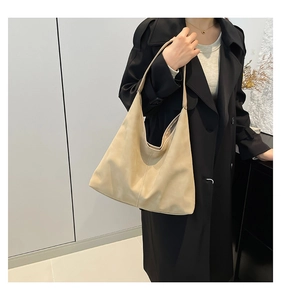 Modella indossa grande borsa hobo beige in morbida pelle opaca per un pendolarismo elegante
