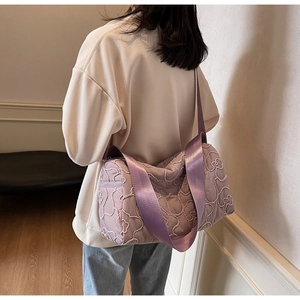 Close-up of lavender quilted fabric bag featuring cute teddy bear embroidery and wide strap