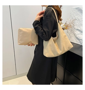 Set borsa tote beige minimalista con pochette coordinata indossata da una modella