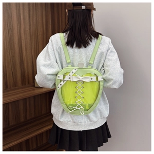 Detail of apple-shaped ita bag in lime green with transparent window and lace-up bow