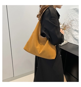 Vista laterale di una borsa tote grande in pelle giallo zenzero su un modello per il lavoro
