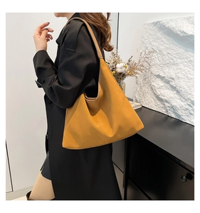 Vista laterale dettagliata della borsa hobo gialla con ampia tracolla e cuciture di pregio