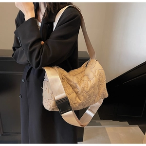 Detail of floral quilted texture on beige nylon crossbody bag with buckle strap