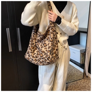 Gros plan d'un grand sac à bandoulière en fausse fourrure léopard porté par un mannequin