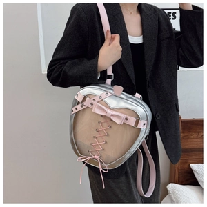 Detail of silver heart-shaped ita bag with pink ribbon lacing and transparent PVC window