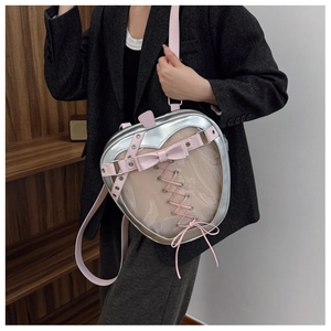 Detail of silver heart-shaped ita bag with transparent window and pink bow accents