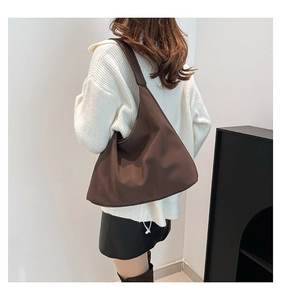 Vista dettagliata di una borsa a tracolla marrone con una silhouette minimalista a mezzaluna