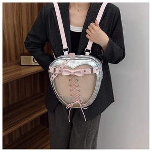 Detail showing apple-shaped ita bag with heart window and pink bow ribbon detail