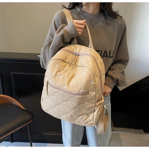 Detail of light beige quilted backpack with cute white bow embroidery for school