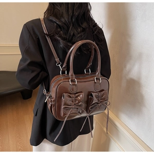Detail view of retro brown oil-wax leather backpack with dual bow pockets and convertible straps