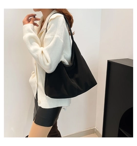 Primo piano della borsa hobo in nylon nero portata a spalla per il pendolarismo quotidiano