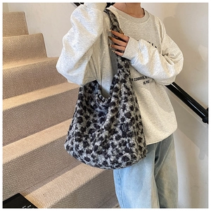 Détail d'un sac cabas en peluche imprimé léopard avec étiquette de marque tissée