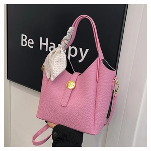Pink lychee texture bucket bag featuring a silk scarf handle and golden metal hardware