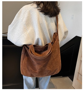 Macro view showing the soft brown faux suede texture and wide strap of the large tote bag