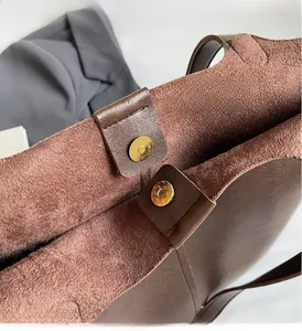 Detail view of brown PU tote bag with soft suede lining and magnetic gold metal clasp