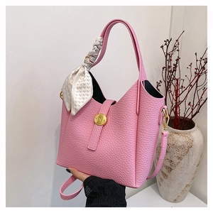 Pink lychee grain bucket bag featuring silk scarf handle and golden hardware detail