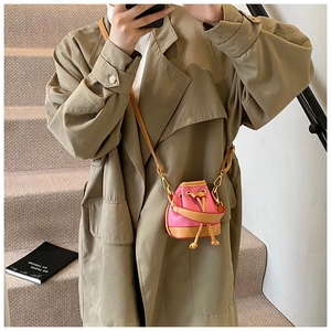 Détail du mini sac seau en cuir rose et kaki avec cordon et boucles dorées