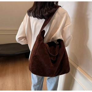Deep brown faux suede tote bag on model showing large capacity and soft texture