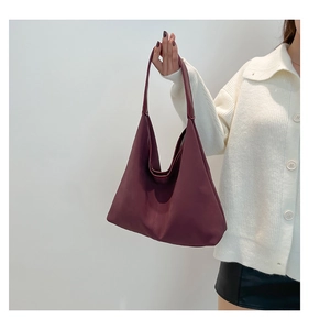 Dettaglio della borsa hobo in pelle bordeaux con trama opaca e grande capacità per ufficio
