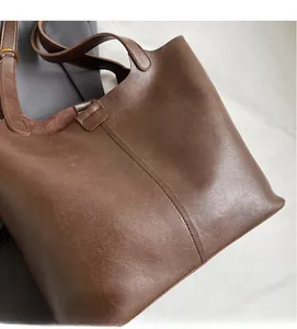Close-up of vintage dark brown faux leather tote with fine texture and vertical stitching