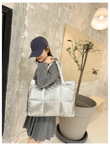 Detailed view of silver quilted tote bag with metallic finish and wide shoulder straps