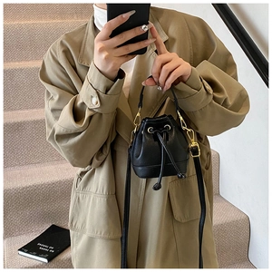 Détail du mini sac seau noir en cuir texturé litchi avec fermeture par cordon coulissant