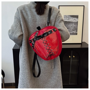 Detail of red strawberry-shaped backpack with clear window and black lace-up bow
